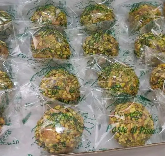 Confezioni singole di paste di pistacchio artigianali siciliane disposte in un vassoio.